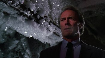 Movie still from “The Dead Pool” (1988), directed by Buddy Van Horn – A man wearing a suit and tie standing in front of a tree; Close Up shot, Low angle
