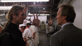 Movie still from “The Dead Pool” (1988), directed by Buddy Van Horn – A group of people standing around in a room; Close Up shot, Over the shoulder angle