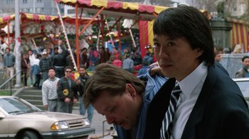 Movie still from “The Dead Pool” (1988), directed by Buddy Van Horn – A couple of men standing next to each other on the street; Close Up shot, Over the shoulder angle