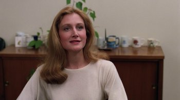 Movie still from “The Dead Pool” (1988), directed by Buddy Van Horn – A woman sitting in front of a table with cups on it; Close Up shot, Over the shoulder angle