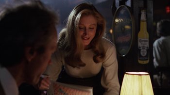 Movie still from “The Dead Pool” (1988), directed by Buddy Van Horn – A woman sitting in front of a man holding a box; Close Up shot, Over the shoulder angle