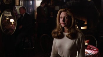 Movie still from “The Dead Pool” (1988), directed by Buddy Van Horn – A woman in a white shirt is standing in front of a bar; Medium shot, Over the shoulder angle