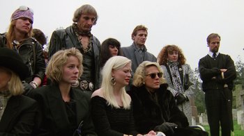 Movie still from “The Dead Pool” (1988), directed by Buddy Van Horn – A group of people sitting next to each other; Medium shot, Low angle
