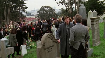 Movie still from “The Dead Pool” (1988), directed by Buddy Van Horn – A group of people standing around a grave in a cemetery; Wide shot, High angle