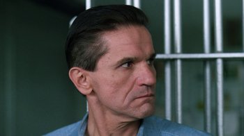 Movie still from “The Dead Pool” (1988), directed by Buddy Van Horn – A person in a jail cell; Close Up shot, Low angle