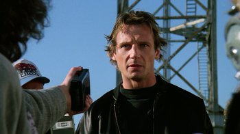 Movie still from “The Dead Pool” (1988), directed by Buddy Van Horn – A person taking a picture of a man in a leather jacket; Close Up shot, Low angle
