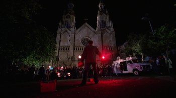 Movie still from “The Dead Pool” (1988), directed by Buddy Van Horn – A man in a red jacket stands in front of a large church; Extreme Wide shot, Low angle