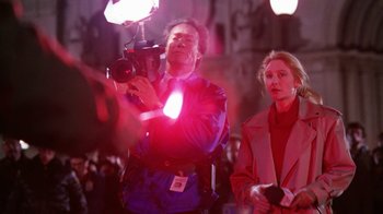 Movie still from “The Dead Pool” (1988), directed by Buddy Van Horn – A man holding a video camera while standing next to a woman; Medium shot, Over the shoulder angle