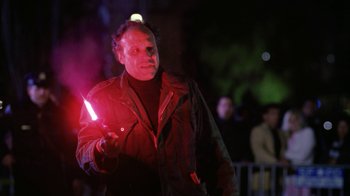 Movie still from “The Dead Pool” (1988), directed by Buddy Van Horn – A man holding a red light in his hand; Medium shot, Low angle