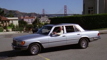 Movie still from “The Dead Pool” (1988), directed by Buddy Van Horn – An older man sitting in the driver's seat of a silver car; Wide shot, High angle