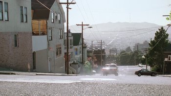 Movie still from “The Dead Pool” (1988), directed by Buddy Van Horn – A car driving down a street next to some buildings; Extreme Wide shot, Low angle