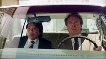 Movie still from “The Dead Pool” (1988), directed by Buddy Van Horn – A man and a woman in a car looking out the window; Medium shot, Low angle