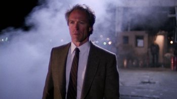 Movie still from “The Dead Pool” (1988), directed by Buddy Van Horn – A man wearing a suit and tie standing in front of a building; Medium shot, Low angle
