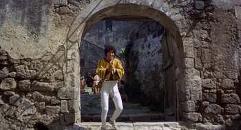 Movie still from “The Decameron” (1971), directed by Pier Paolo Pasolini – A man standing in front of an archway; Wide shot, Low angle