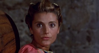 Movie still from “The Decameron” (1971), directed by Pier Paolo Pasolini – A person wearing a dress; Close Up shot, Over the shoulder angle