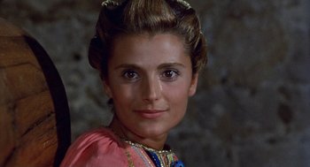 Movie still from “The Decameron” (1971), directed by Pier Paolo Pasolini – A person wearing a dress; Close Up shot, Over the shoulder angle