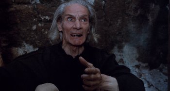 Movie still from “The Decameron” (1971), directed by Pier Paolo Pasolini – An old man with long white hair is pointing to the side; Close Up shot, Low angle