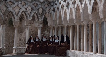 Movie still from “The Decameron” (1971), directed by Pier Paolo Pasolini – A group of nuns sitting in front of an archway; Extreme Wide shot, High angle