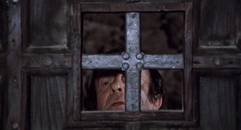 Movie still from “The Decameron” (1971), directed by Pier Paolo Pasolini – An old man looking through a metal gate; Close Up shot, Low angle