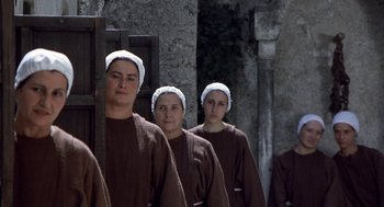 Movie still from “The Decameron” (1971), directed by Pier Paolo Pasolini – A group of women in brown robes and white hats; Medium shot, Low angle