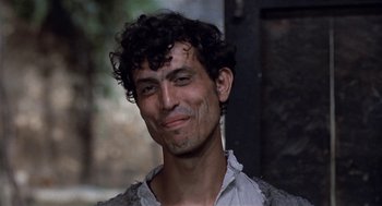 Movie still from “The Decameron” (1971), directed by Pier Paolo Pasolini – A person with curly black hair; Close Up shot, Low angle