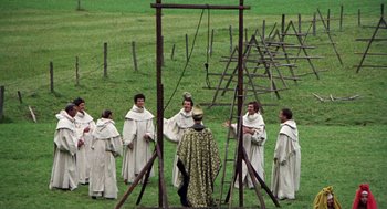 Movie still from “The Decameron” (1971), directed by Pier Paolo Pasolini – A group of men standing next to each other in a field; Wide shot, High angle