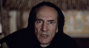 Movie still from “The Decameron” (1971), directed by Pier Paolo Pasolini – An older man with a black hooded jacket; Close Up shot, Low angle