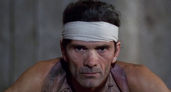 Movie still from “The Decameron” (1971), directed by Pier Paolo Pasolini – A person with a bandage on his head; Close Up shot, Low angle