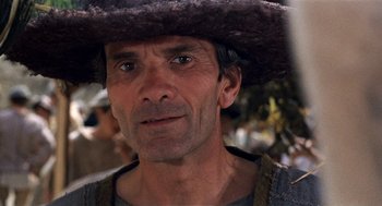 Movie still from “The Decameron” (1971), directed by Pier Paolo Pasolini – A person wearing a hat; Close Up shot, Over the shoulder angle