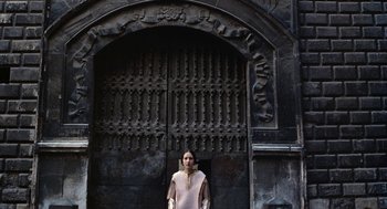 Movie still from “The Decameron” (1971), directed by Pier Paolo Pasolini – A woman standing in front of an old building; Wide shot, Low angle