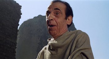 Movie still from “The Decameron” (1971), directed by Pier Paolo Pasolini – An old man wearing a robe and a scarf; Close Up shot, Low angle