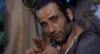 Movie still from “The Decameron” (1971), directed by Pier Paolo Pasolini – A person with a hand gesture; Close Up shot, Low angle