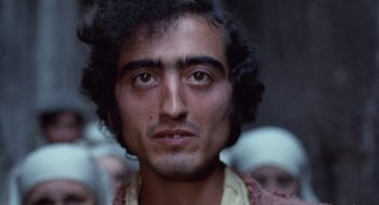 Movie still from “The Decameron” (1971), directed by Pier Paolo Pasolini – A person with a crowd of people in the background; Close Up shot, Low angle