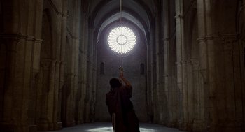 Movie still from “The Decameron” (1971), directed by Pier Paolo Pasolini – A person is hanging from a rope inside a cathedral; Extreme Wide shot, Low angle