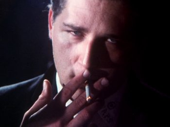 Movie still from “The Decline of Western Civilization” (1981), directed by Penelope Spheeris – A person smoking a cigarette; Close Up shot, Low angle