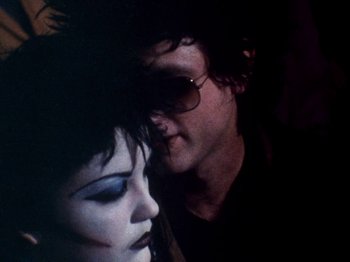 Movie still from “The Decline of Western Civilization” (1981), directed by Penelope Spheeris – A man and a woman face to face in a dark room; Close Up shot, Over the shoulder angle