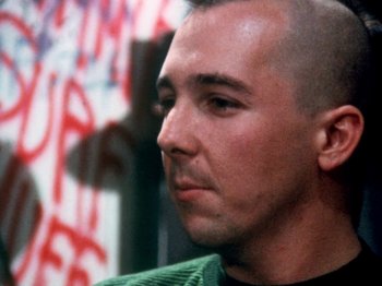 Movie still from “The Decline of Western Civilization” (1981), directed by Penelope Spheeris – A person wearing a green shirt; Close Up shot, Low angle