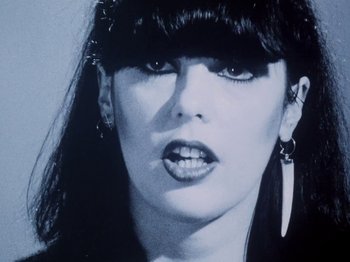Movie still from “The Decline of Western Civilization” (1981), directed by Penelope Spheeris – A woman's face in black and white; Close Up shot, Low angle