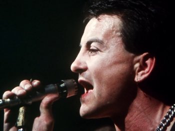 Movie still from “The Decline of Western Civilization” (1981), directed by Penelope Spheeris – A person singing into a microphone; Close Up shot, Low angle