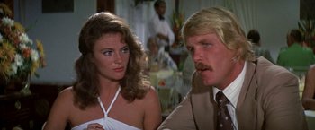 Movie still from “The Deep” (1977), directed by Peter Yates – A man and a woman sitting next to each other; Close Up shot, Over the shoulder angle