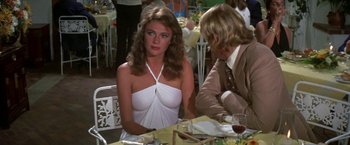 Movie still from “The Deep” (1977), directed by Peter Yates – A woman sitting at a table with a man; Medium shot, Over the shoulder angle