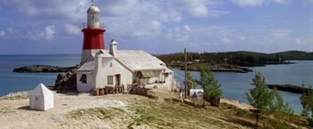 Movie still from “The Deep” (1977), directed by Peter Yates – Two men are standing on a hill near a lighthouse; Extreme Wide shot, Low angle