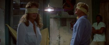 Movie still from “The Deep” (1977), directed by Peter Yates – A woman and a blindfolded man standing in a room; Medium shot, Over the shoulder angle