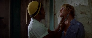 Movie still from “The Deep” (1977), directed by Peter Yates – A man with a yellow hat is touching a woman's face; Close Up shot, Over the shoulder angle