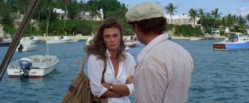 Movie still from “The Deep” (1977), directed by Peter Yates – A woman standing next to a man on a pier; Medium shot, Over the shoulder angle