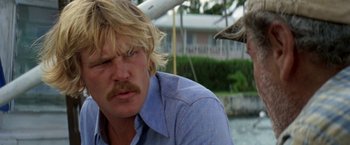 Movie still from “The Deep” (1977), directed by Peter Yates – A man with blonde hair and a mustache; Close Up shot, Low angle