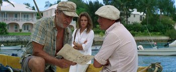 Movie still from “The Deep” (1977), directed by Peter Yates – Two men and a woman are looking at a map; Medium shot, Over the shoulder angle