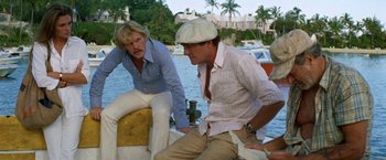 Movie still from “The Deep” (1977), directed by Peter Yates – Two men sitting on the side of a boat in the water; Medium shot, Over the shoulder angle