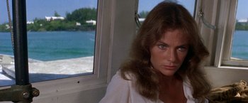 Movie still from “The Deep” (1977), directed by Peter Yates – A woman in a white shirt looking out of a window; Close Up shot, Over the shoulder angle
