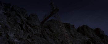 Movie still from “The Deep” (1977), directed by Peter Yates – A crane on top of a mountain at night; Extreme Wide shot, Low angle